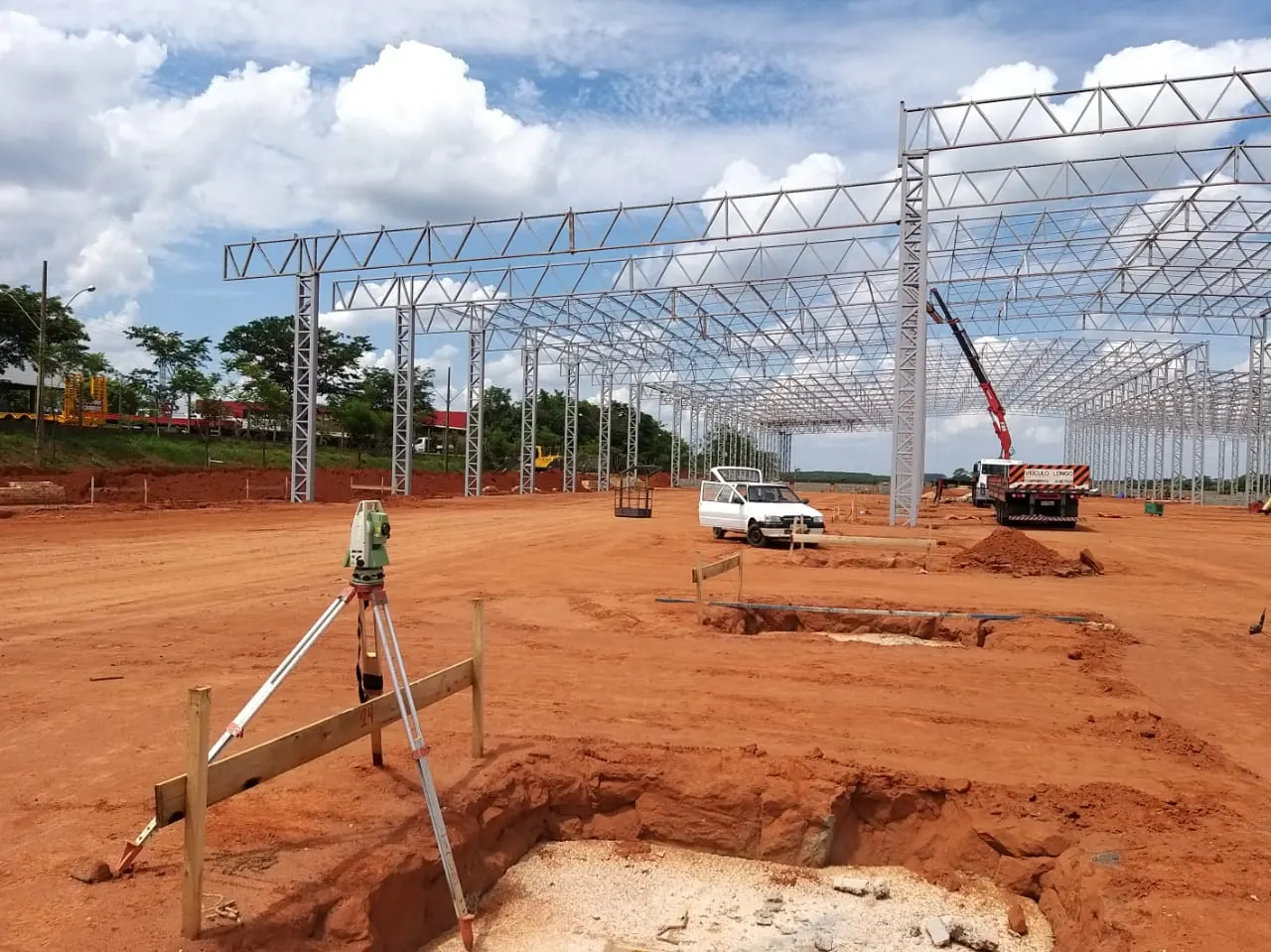 Estação total diante da estrutura metálica do novo barracão Facchini em Roseira, sobre terra vermelha