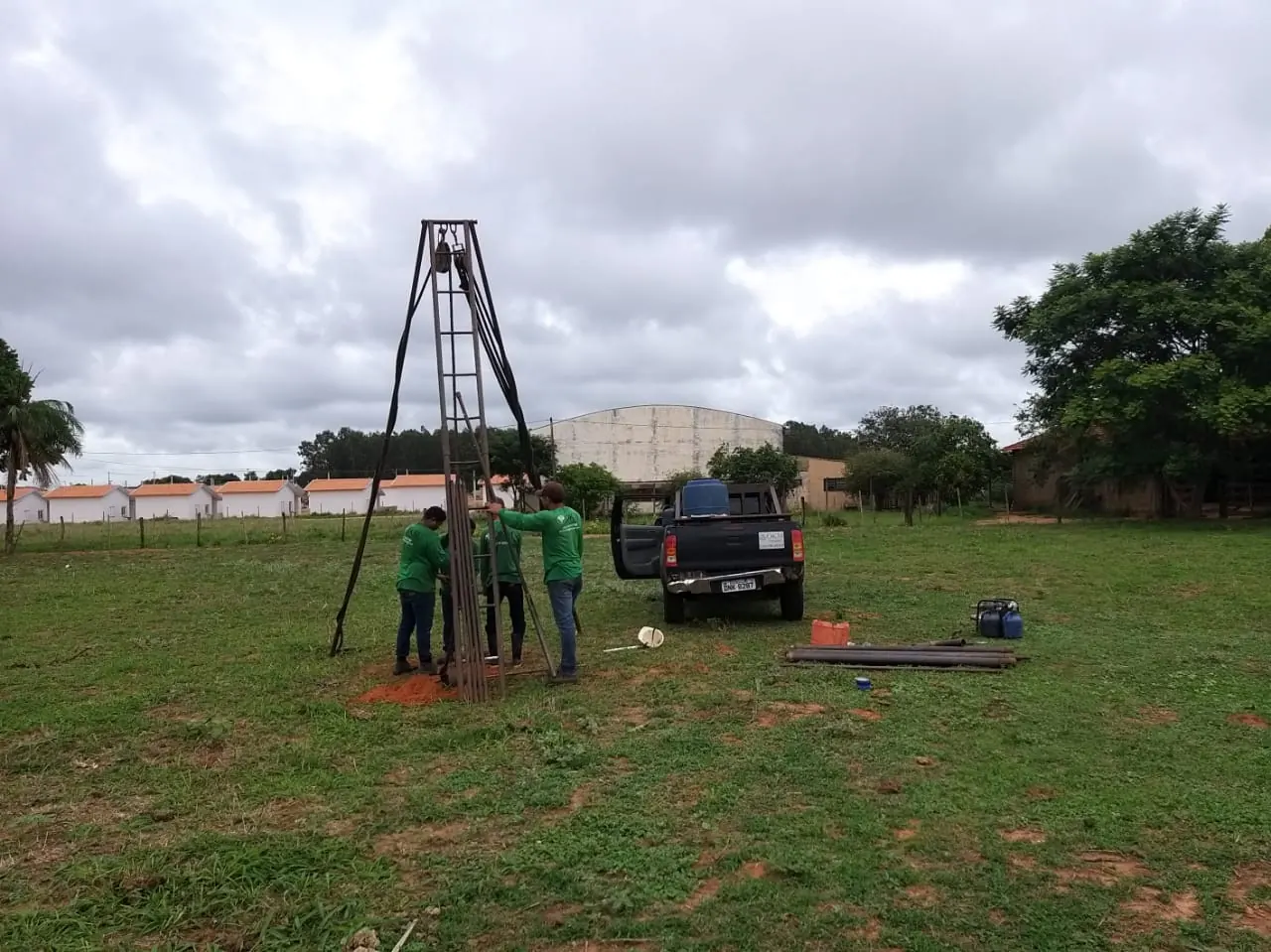 Equipe de sondagem com tripé de perfuração e caminhonete no campo do loteamento Jardim Ipanema 2, em Penápolis